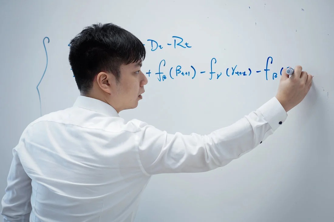 Patrick Pun discussing mathematical ideas at a whiteboard